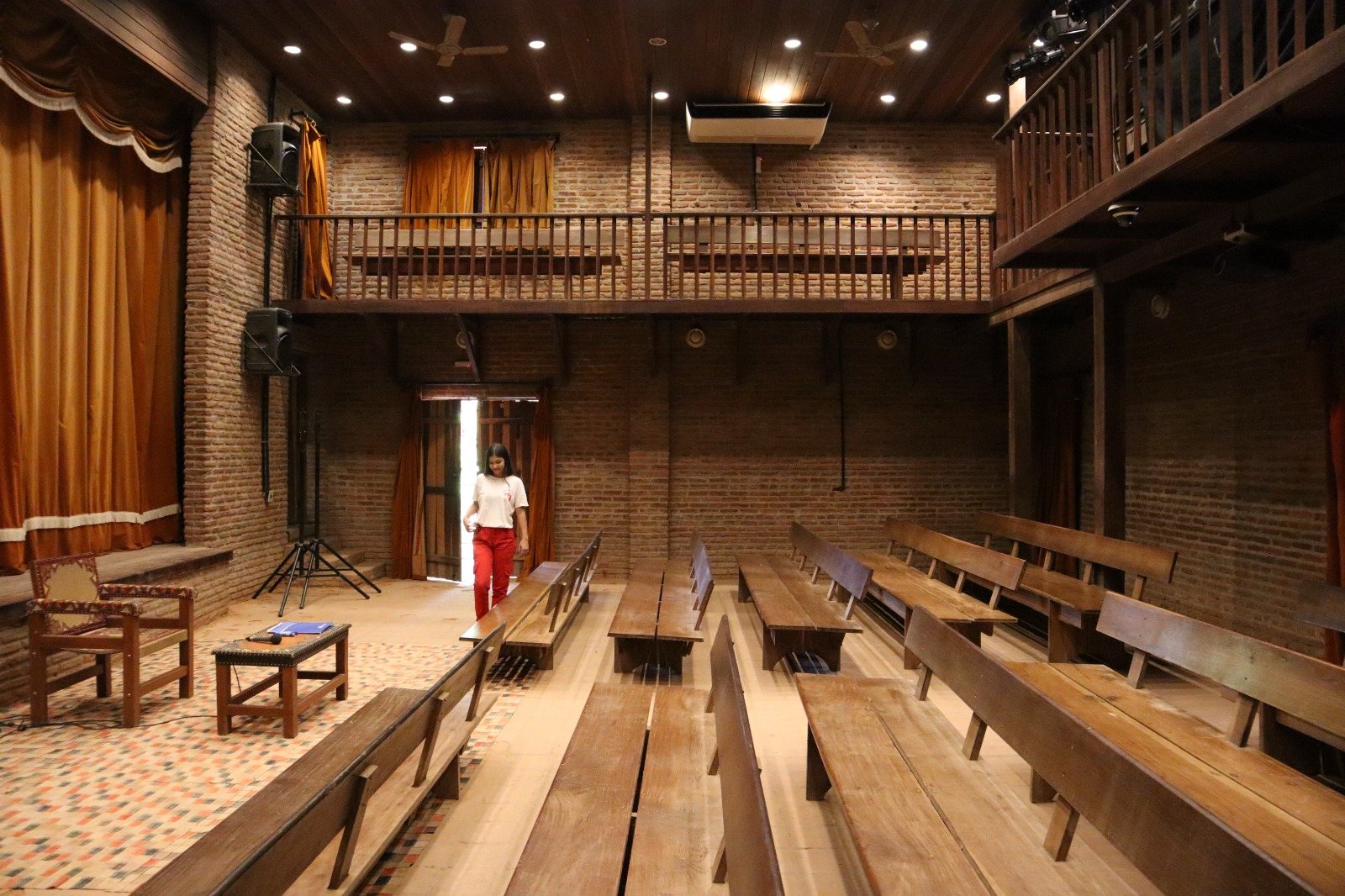 Plateia do Teatro Violeta Arraes, com bancos e galeria de madeira e paredes de tijolo